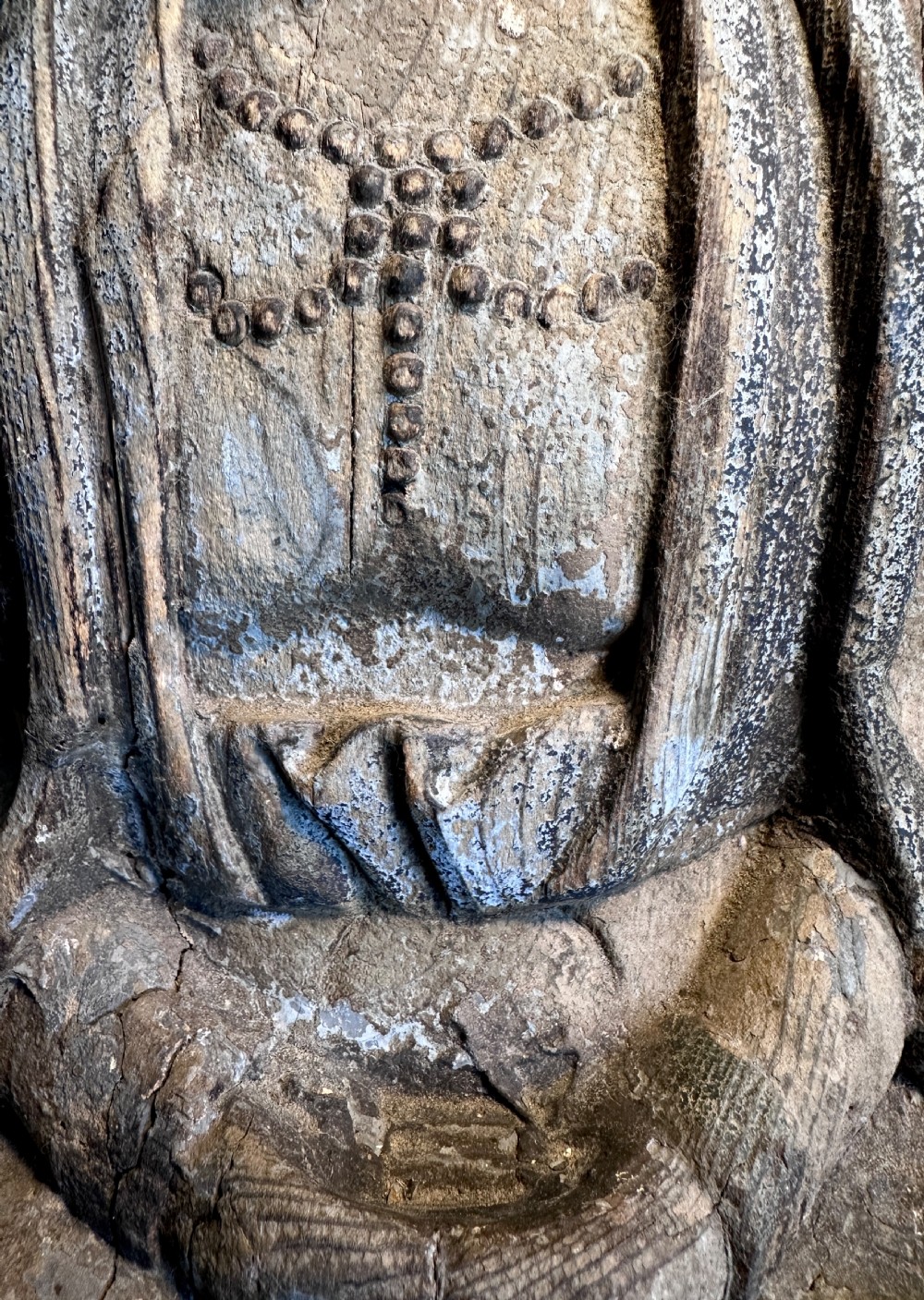 A carved wooden statue of a seated Buddha with a high headpiece and weathered finish. View XI
