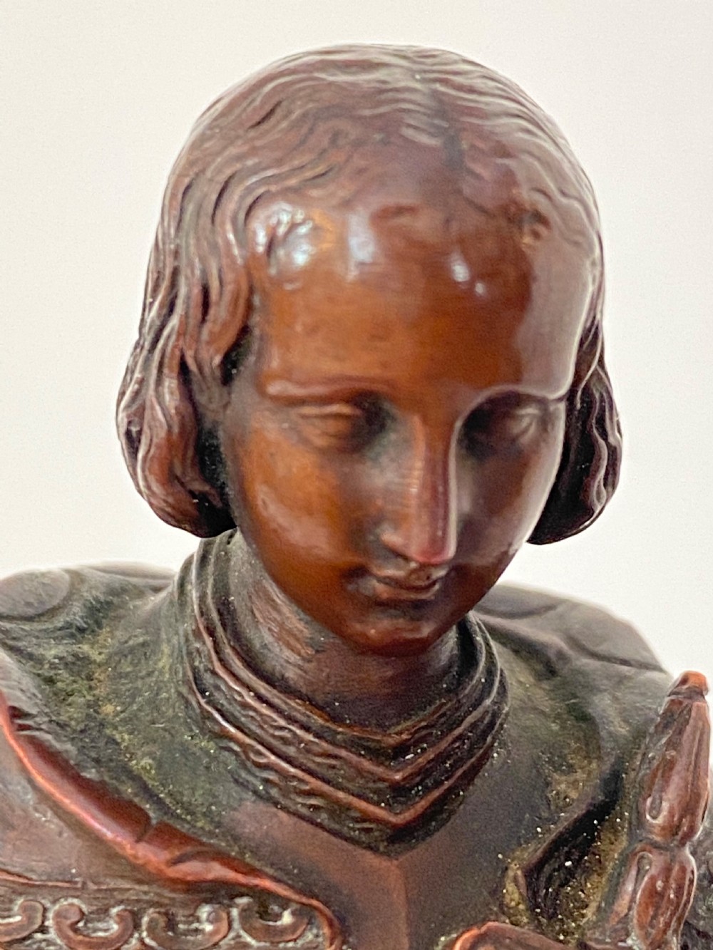 A 19th-century dark bronze sculpture depicting Joan of Arc in suit of armour with a sword, mounted on a round reddish marble base. View VI
