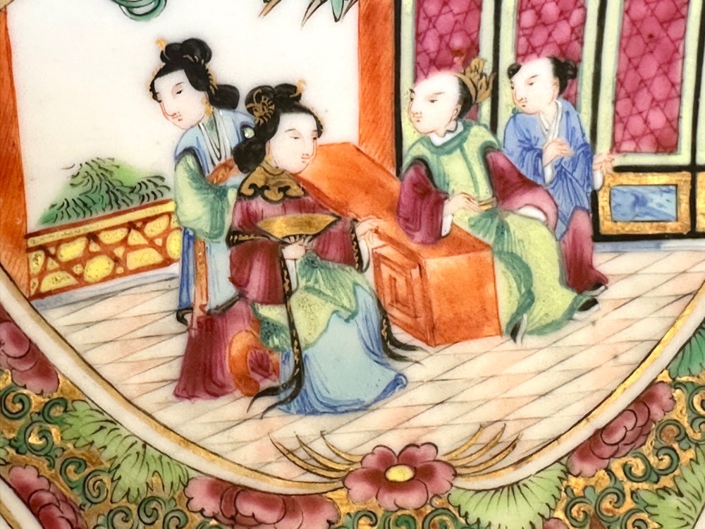 A square Chinese porcelain dish with lobed corners featuring painted reserves of figural court scenes, birds, and flowers set against a dense green scroll and butterfly ground. View VII