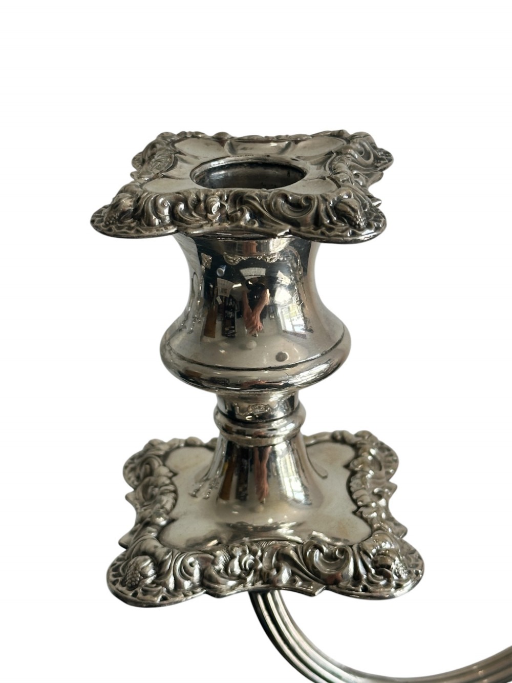 A matching pair of silver-plated three-light candelabra featuring ornate scroll-formed arms, foliate-moulded bases, and white taper candles. View VI