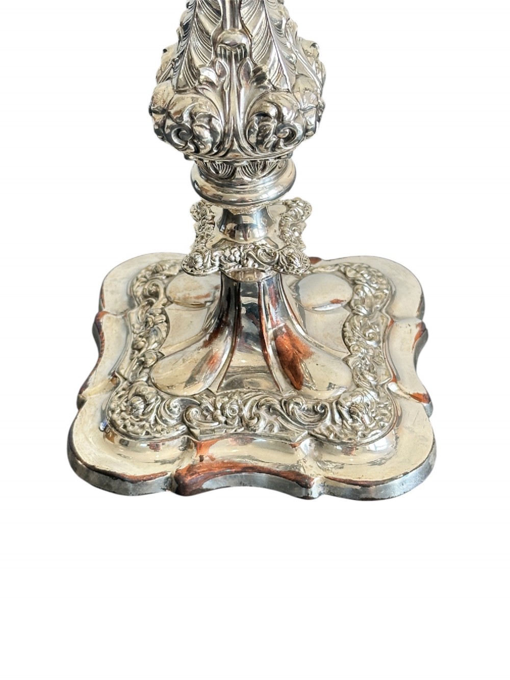 A matching pair of silver-plated three-light candelabra featuring ornate scroll-formed arms, foliate-moulded bases, and white taper candles. View VIII