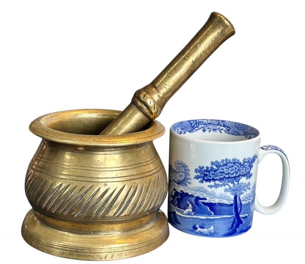 An eighteenth-century cast brass pestle and mortar featuring diagonal carved fluting around the main bowl and a flared rim. View VI