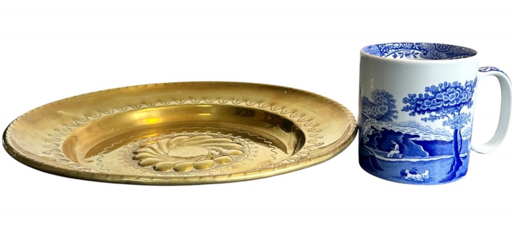 A circular brass alms dish featuring a central gadrooned swirl motif surrounded by punched geometric border patterns. View III