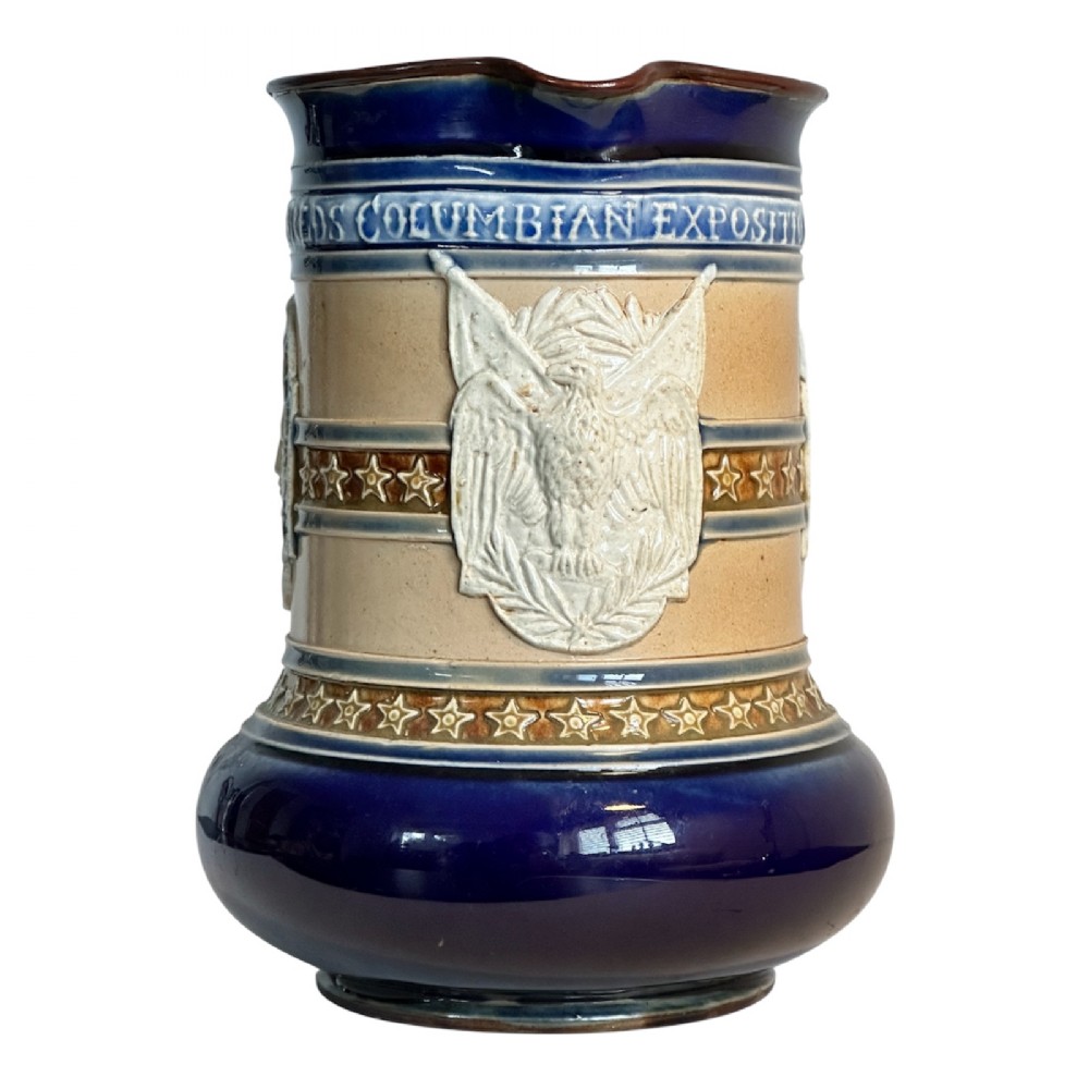 Doulton Lambeth salt-glazed stoneware jug featuring deep cobalt blue borders, buff central body, star motifs, and a relief portrait medallion of Christopher Columbus. View III