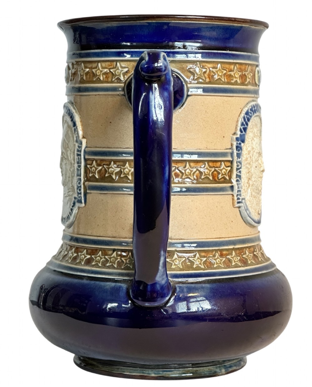 Doulton Lambeth salt-glazed stoneware jug featuring deep cobalt blue borders, buff central body, star motifs, and a relief portrait medallion of Christopher Columbus. View VIII