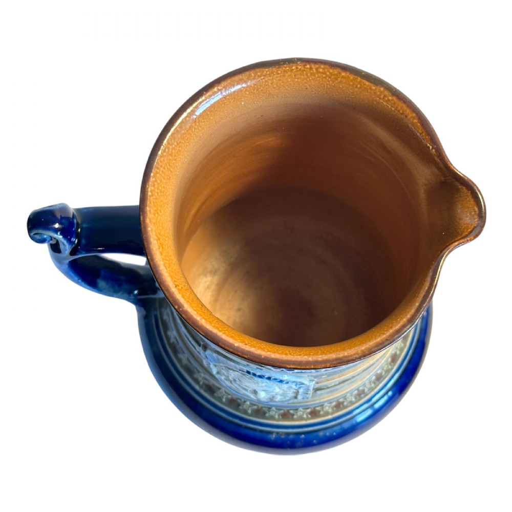Doulton Lambeth salt-glazed stoneware jug featuring deep cobalt blue borders, buff central body, star motifs, and a relief portrait medallion of Christopher Columbus. View X