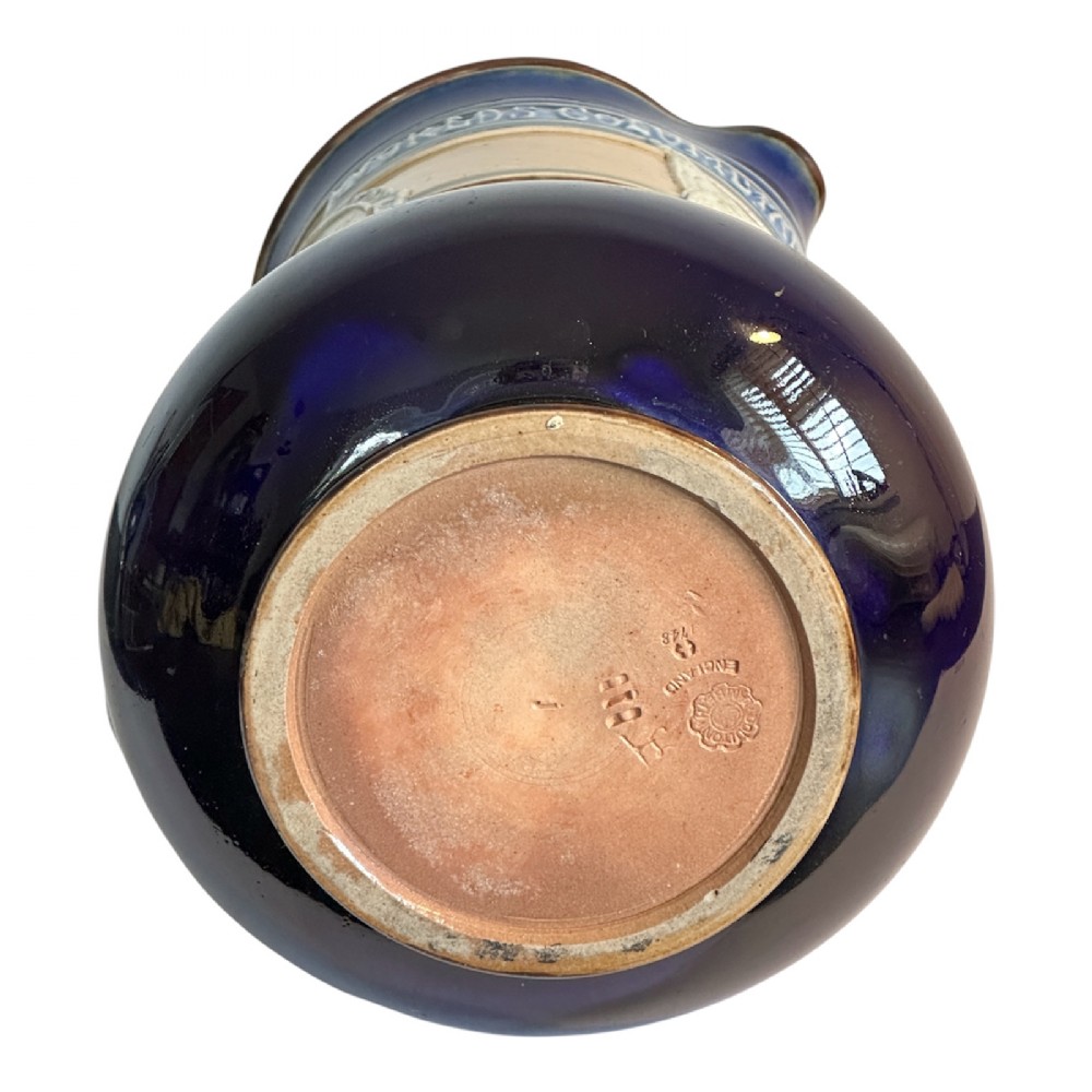 Doulton Lambeth salt-glazed stoneware jug featuring deep cobalt blue borders, buff central body, star motifs, and a relief portrait medallion of Christopher Columbus. View XII