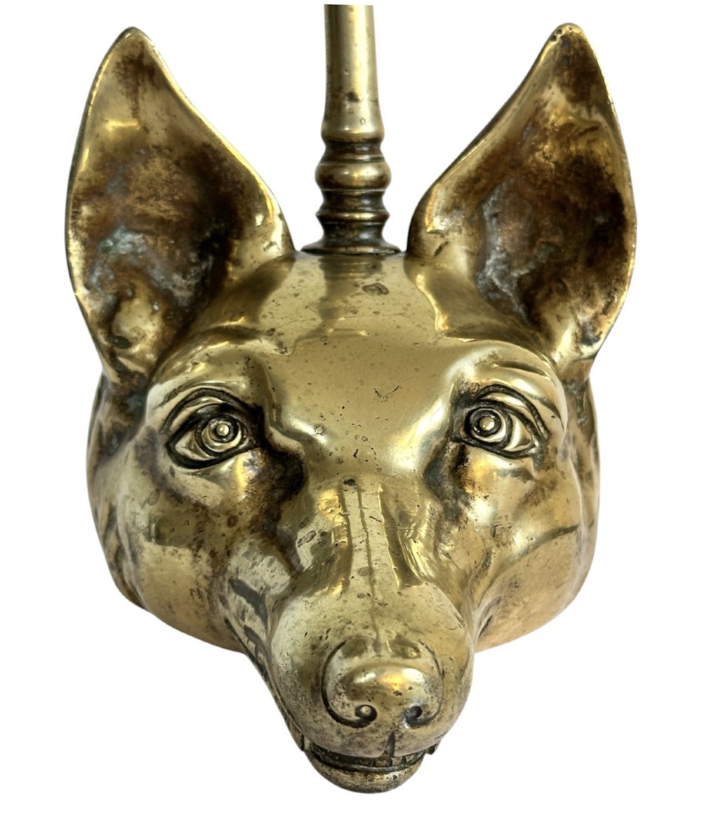 A cast brass doorstop shaped as a fox head with an attached vertical shaft ending in an oval handle. View IV