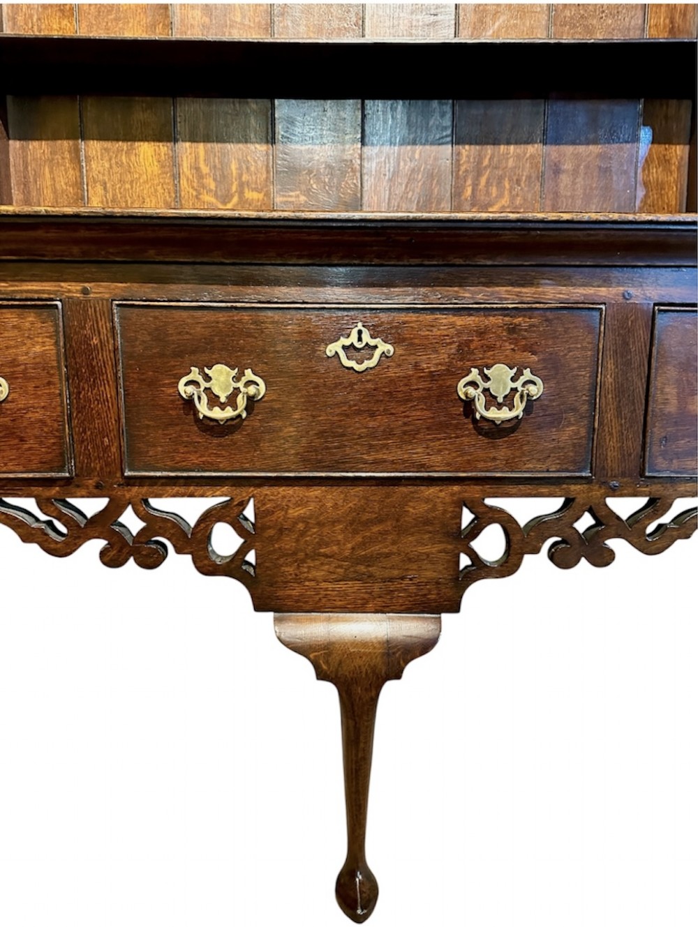 A dark oak George III dresser featuring an open plate rack top with side cupboards above three base drawers supported on cabriole legs. View VII