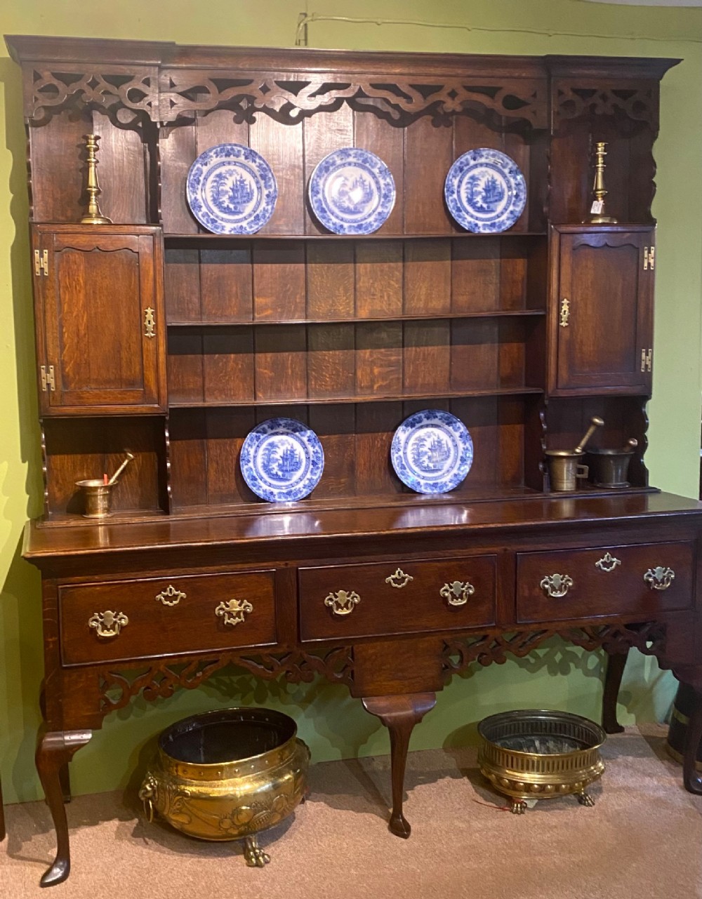 A dark oak George III dresser featuring an open plate rack top with side cupboards above three base drawers supported on cabriole legs. View XI