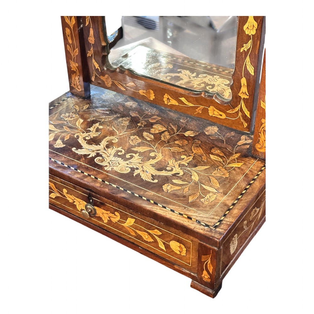 An antique Dutch walnut dressing table mirror featuring intricate floral marquetry inlay across the frame, support posts, and single-drawer base. View IV