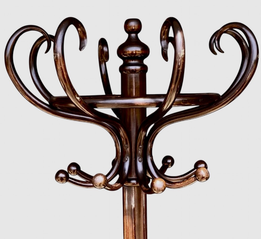 A tall dark brown bentwood coat and hat stand featuring double curved hooks, a central turned column, an umbrella drip ring, and splayed legs. View II