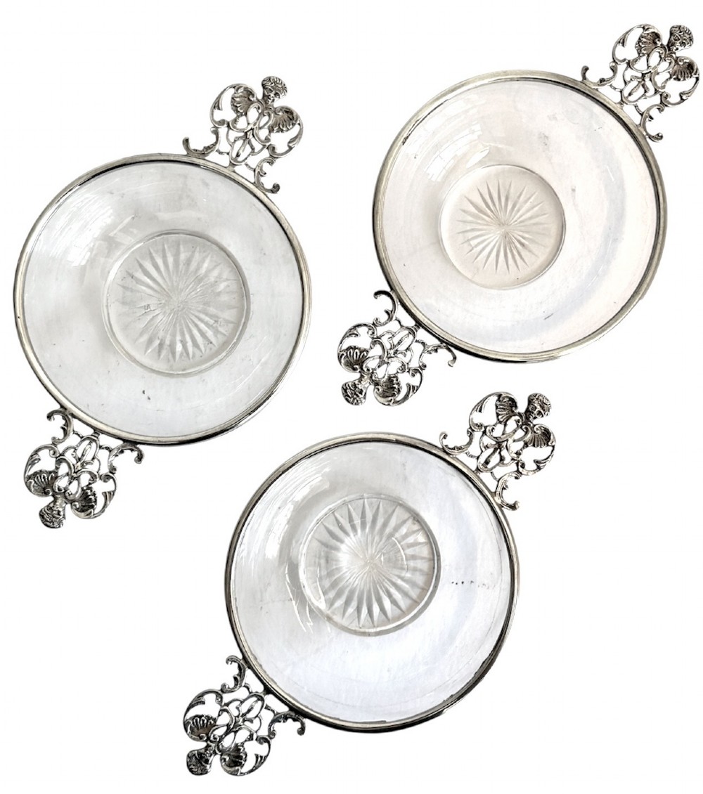A set of three clear glass bowls featuring sterling silver rims and pierced scroll handles. View II