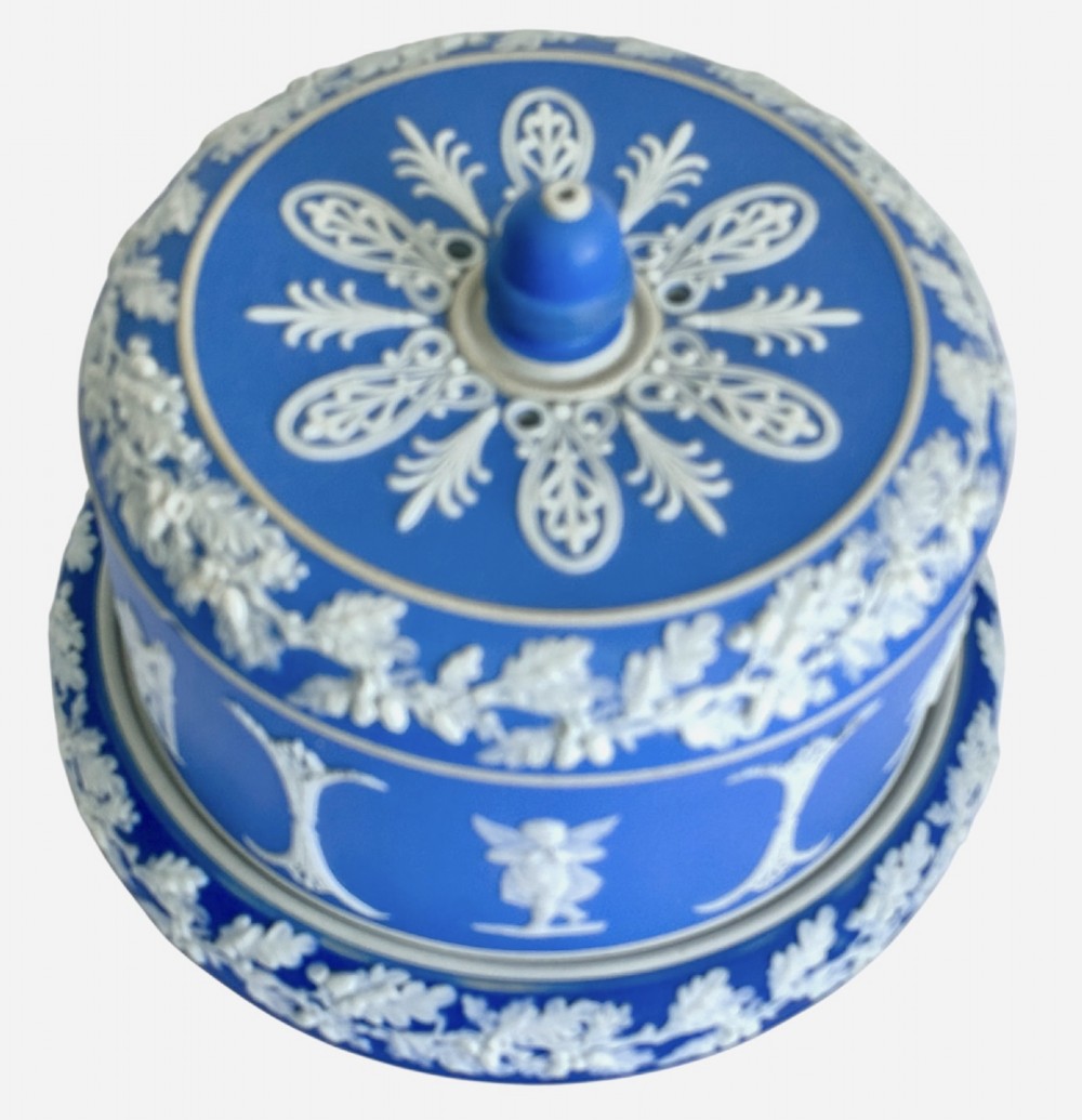 A Victorian blue Jasperware cheese dome and base decorated with white neoclassical figures, oak leaf garlands, and a central finial handle. View II