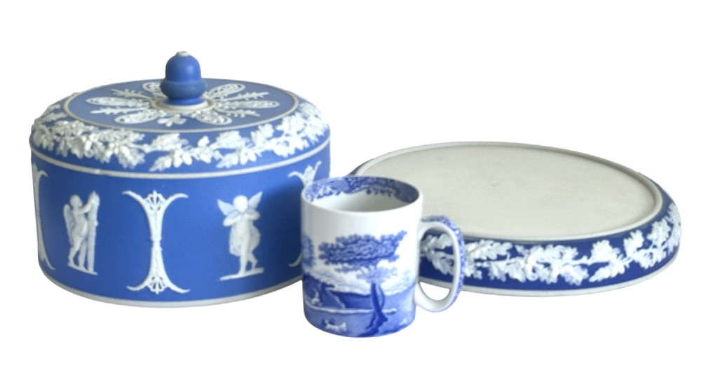 A Victorian blue Jasperware cheese dome and base decorated with white neoclassical figures, oak leaf garlands, and a central finial handle. View VI