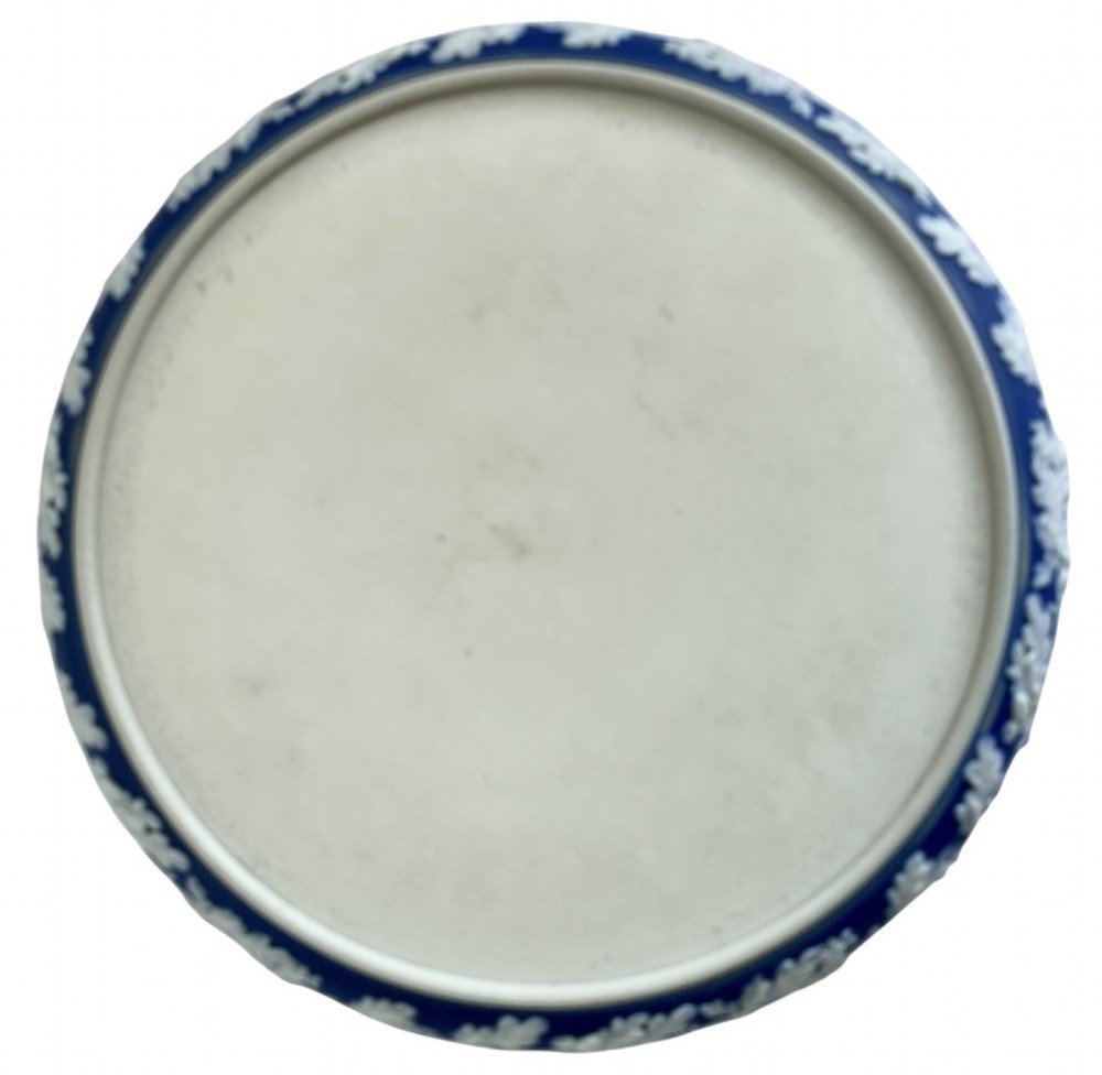 A Victorian blue Jasperware cheese dome and base decorated with white neoclassical figures, oak leaf garlands, and a central finial handle. View VII