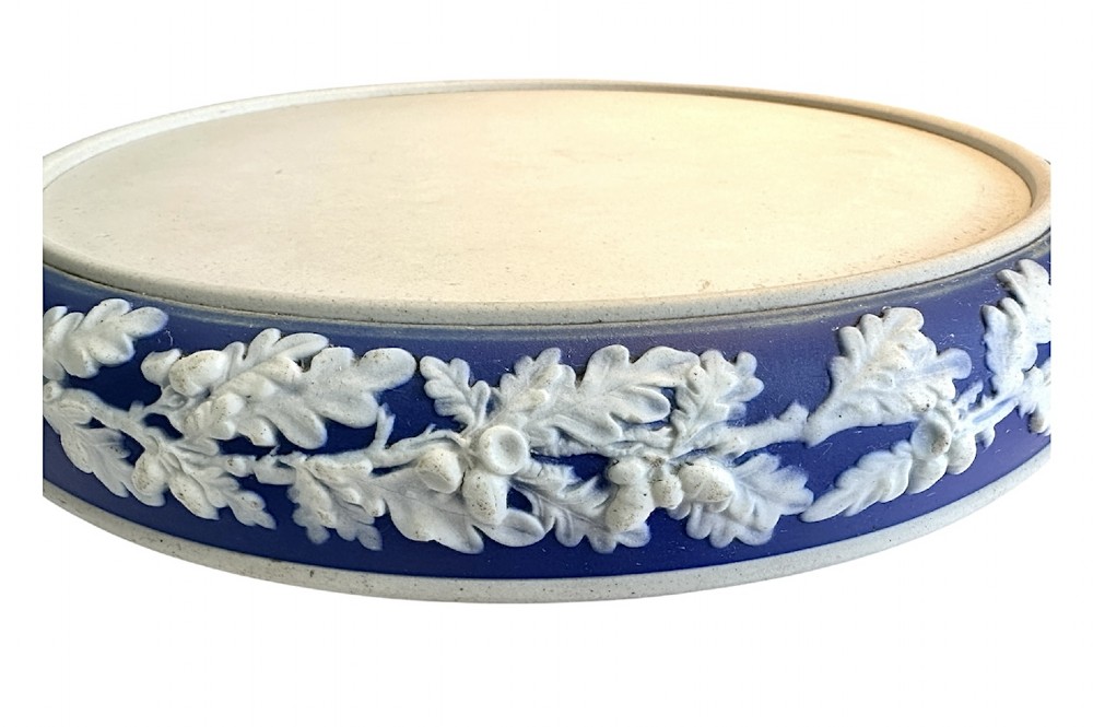 A Victorian blue Jasperware cheese dome and base decorated with white neoclassical figures, oak leaf garlands, and a central finial handle. View XII