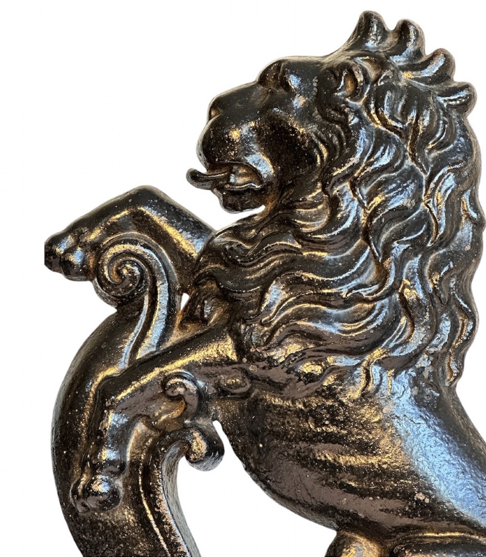 A side profile view of a dark cast iron doorstop depicting a rampant lion mounted on a stepped rectangular base. View IV