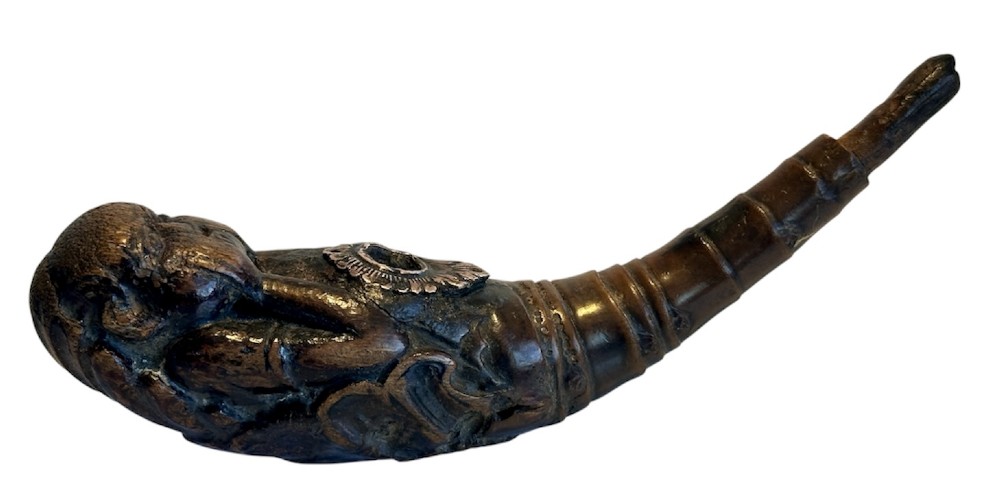 A dark brown carved bamboo smoking pipe shaped into a figurative human form along the bowl with a tapered bamboo stem. View IV