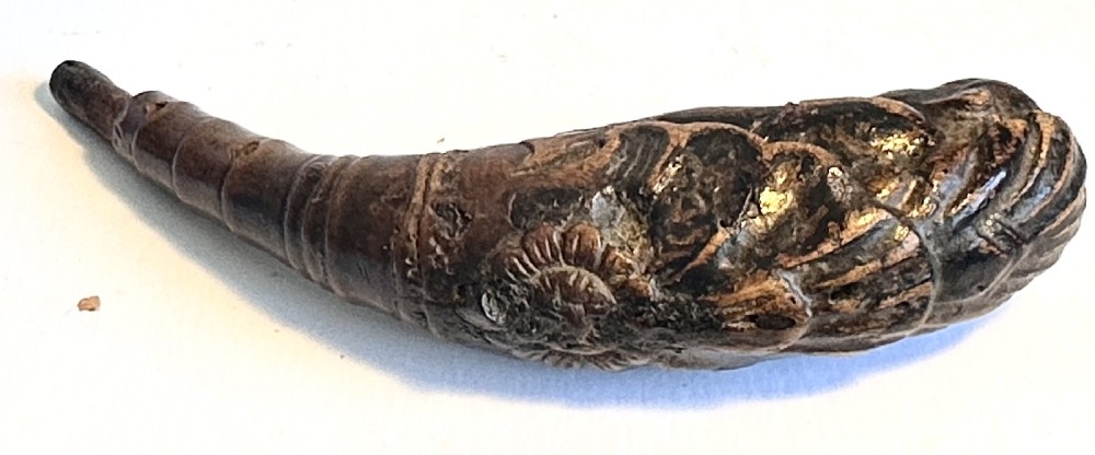 A dark brown carved bamboo smoking pipe shaped into a figurative human form along the bowl with a tapered bamboo stem. View VIII