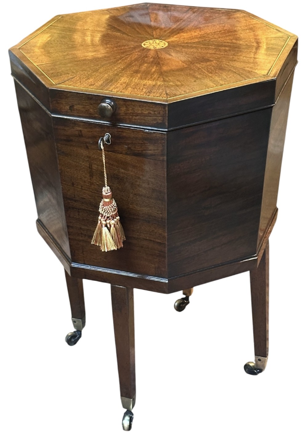 An octagonal George III mahogany cellarette on tapered legs with brass castors, featuring a starburst veneered lid and inlaid detailing. View II
