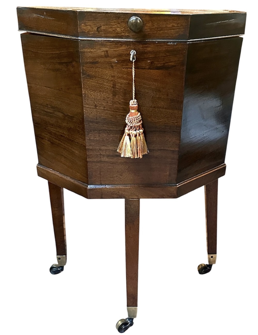 An octagonal George III mahogany cellarette on tapered legs with brass castors, featuring a starburst veneered lid and inlaid detailing. View V