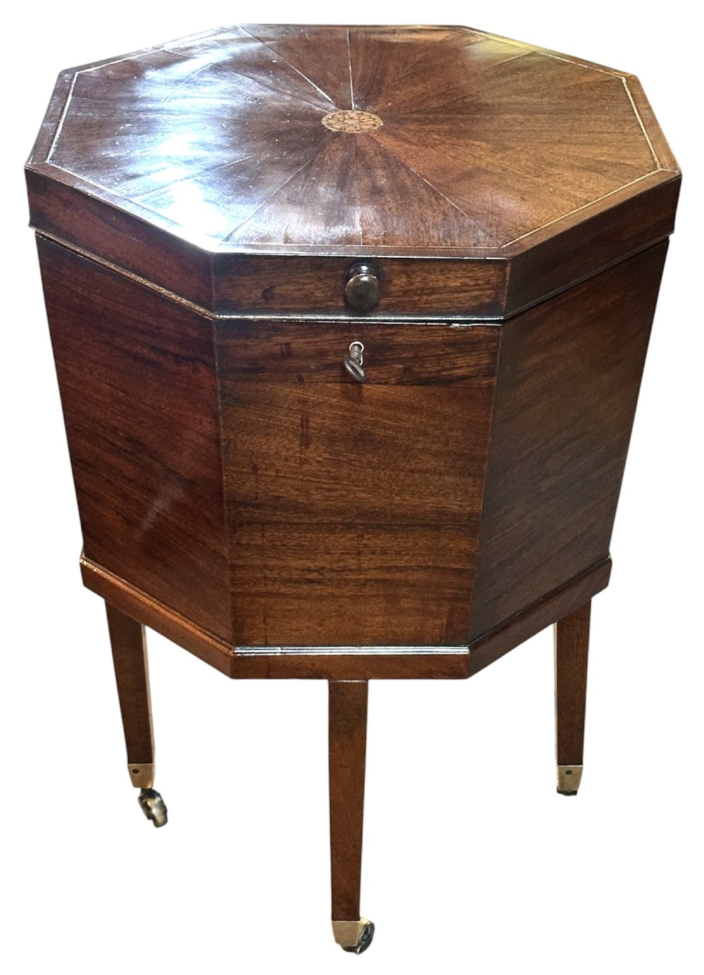 An octagonal George III mahogany cellarette on tapered legs with brass castors, featuring a starburst veneered lid and inlaid detailing. View VIII