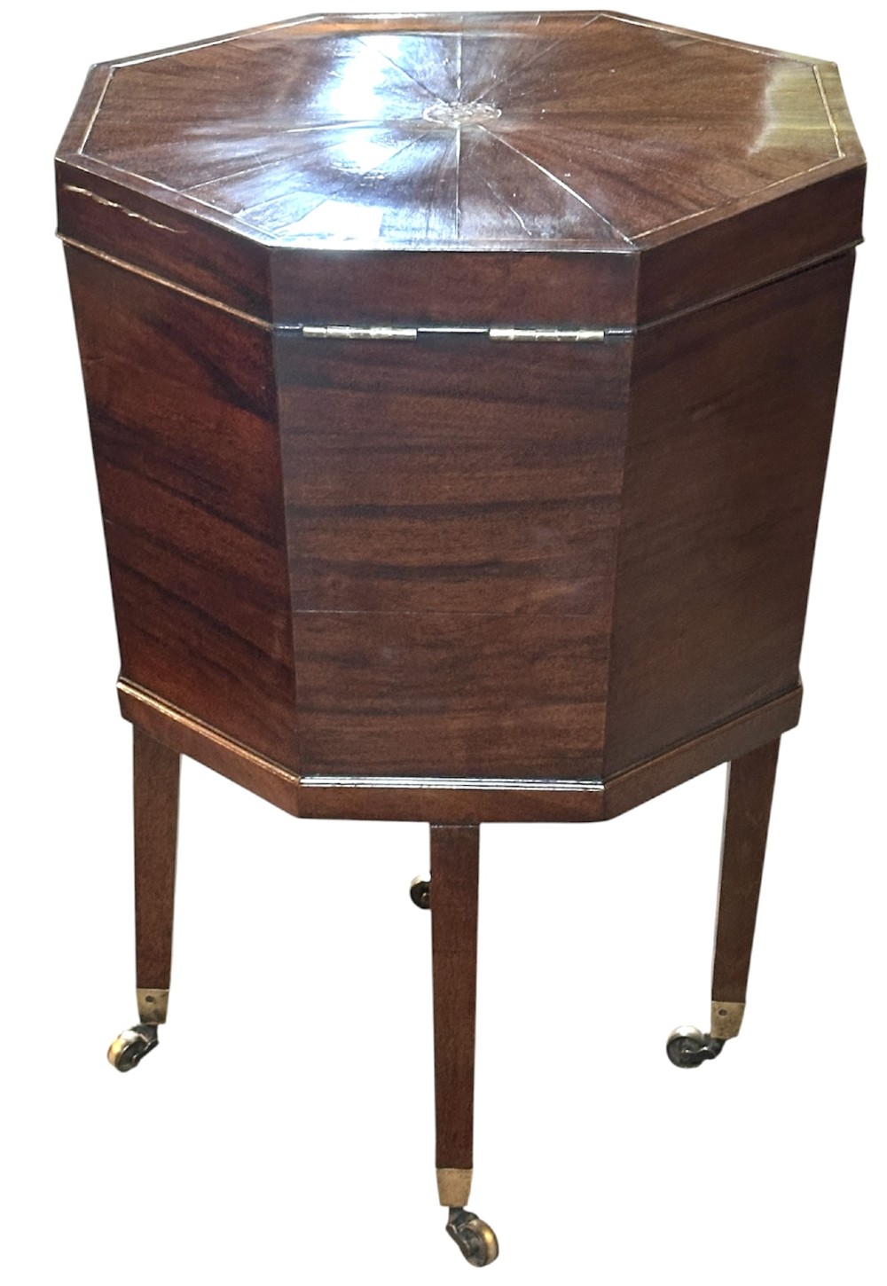 An octagonal George III mahogany cellarette on tapered legs with brass castors, featuring a starburst veneered lid and inlaid detailing. View XI
