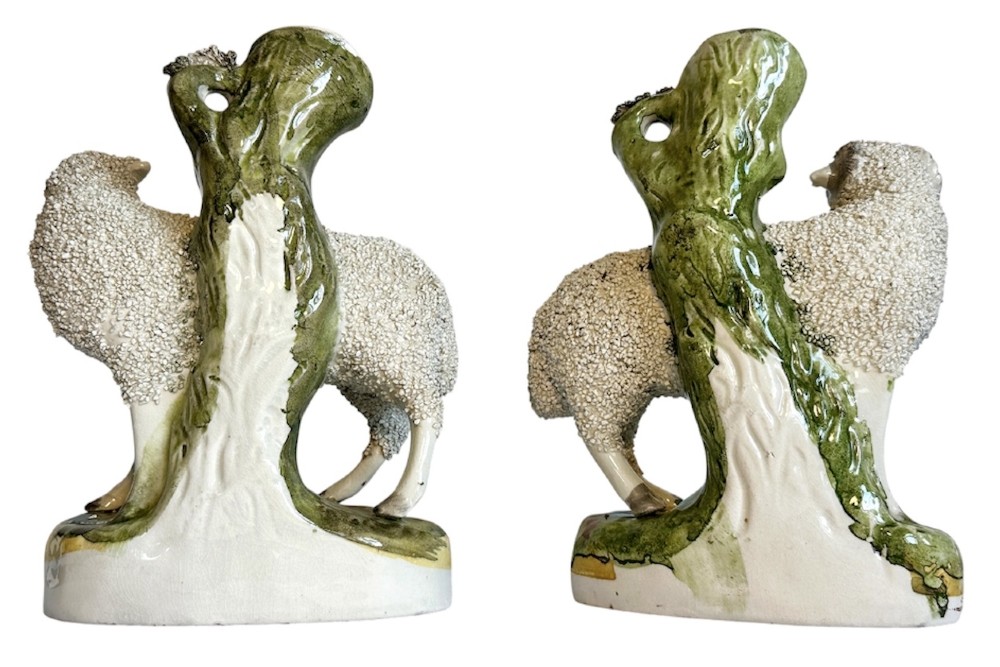 A pair of Victorian Staffordshire earthenware spill vases depicting textured woolly sheep standing alongside green tree trunk vessels. View II