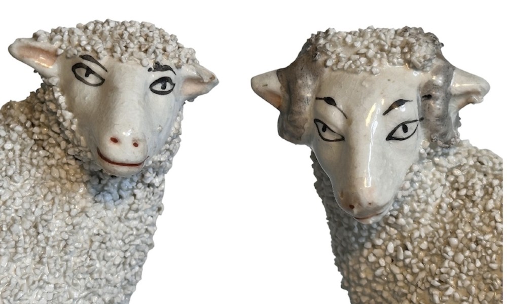 A pair of Victorian Staffordshire earthenware spill vases depicting textured woolly sheep standing alongside green tree trunk vessels. View V