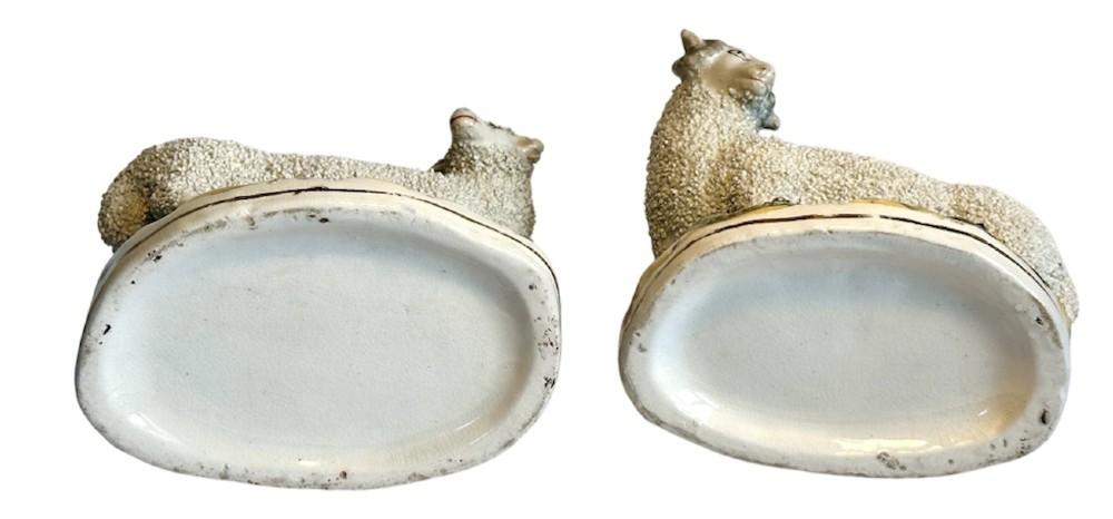 A pair of Victorian Staffordshire earthenware spill vases depicting textured woolly sheep standing alongside green tree trunk vessels. View IX