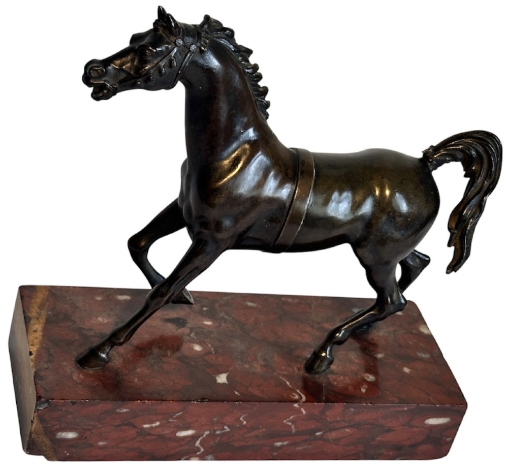 A dark patinated bronze sculpture of a trotting stallion mounted on a rectangular veined red marble plinth. View III