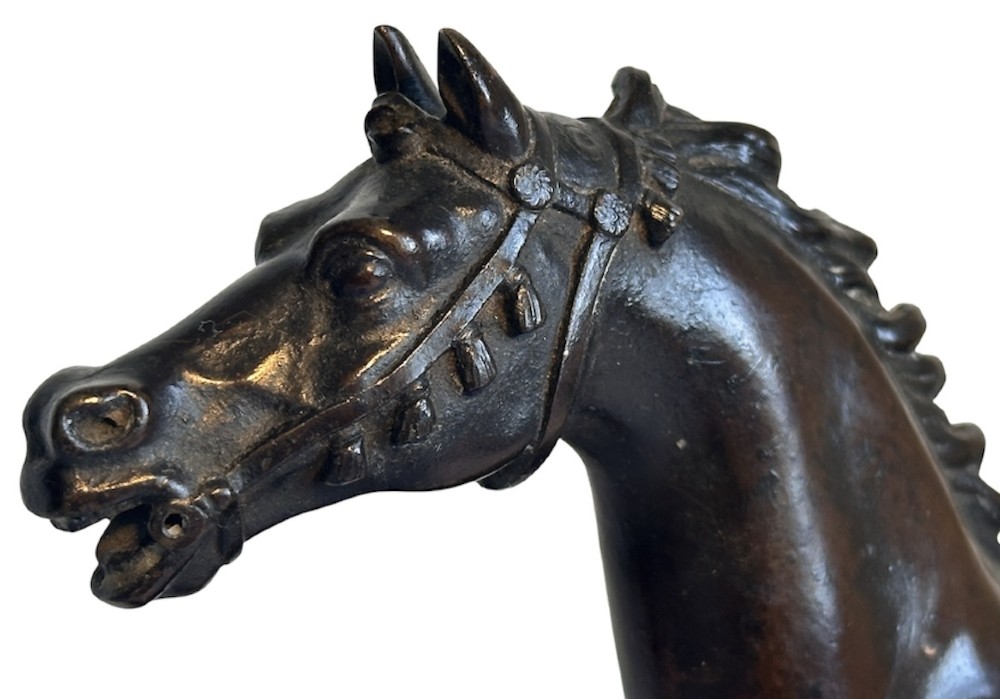 A dark patinated bronze sculpture of a trotting stallion mounted on a rectangular veined red marble plinth. View VI