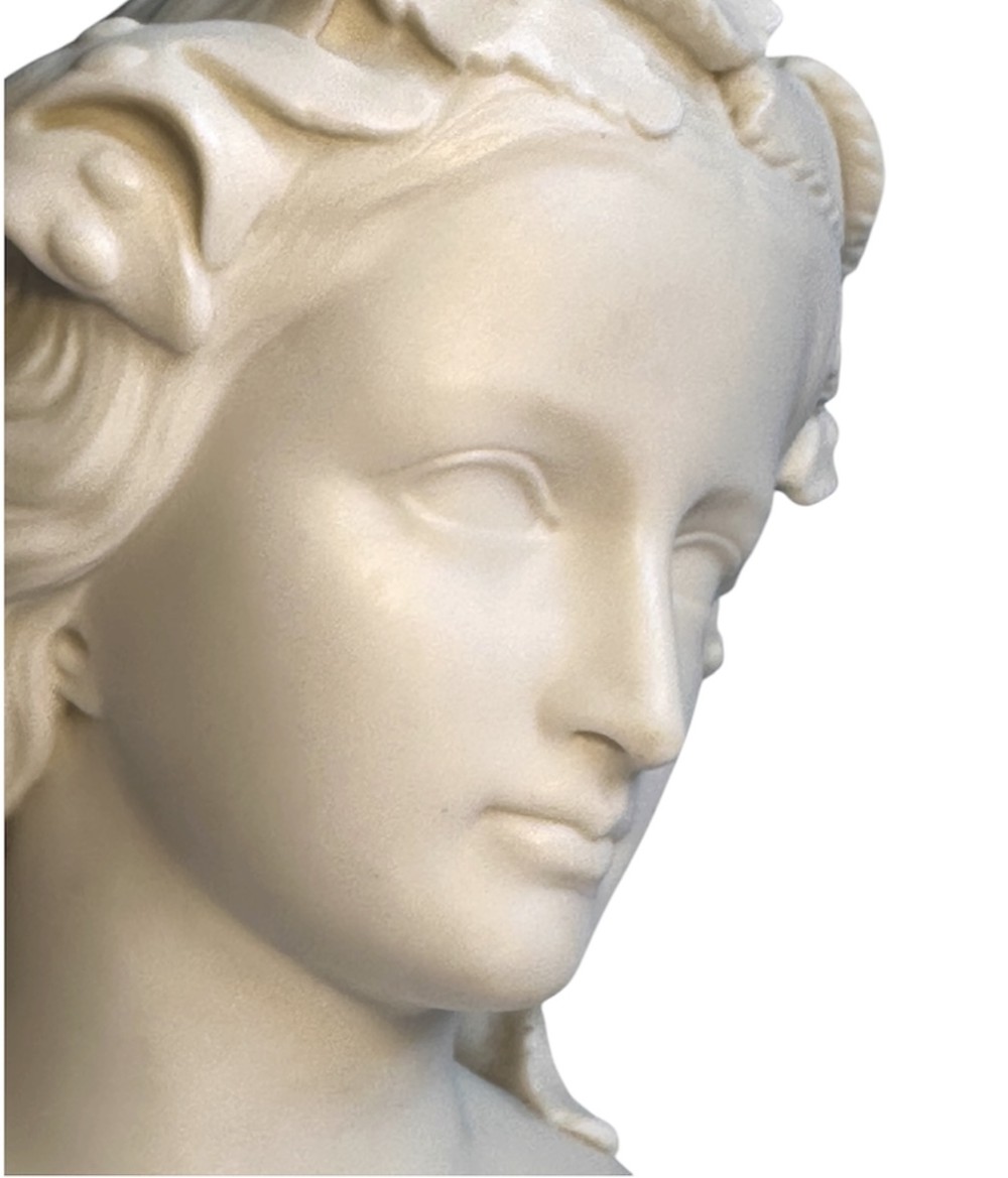 A nineteenth-century off-white Parian porcelain bust depicting a young woman with a floral headpiece draped in classical robes on a turned socle. View IX