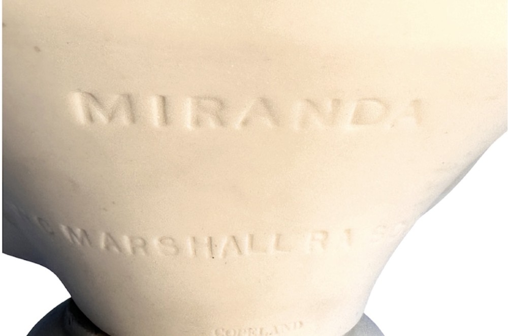 A nineteenth-century off-white Parian porcelain bust depicting a young woman with a floral headpiece draped in classical robes on a turned socle. View XI