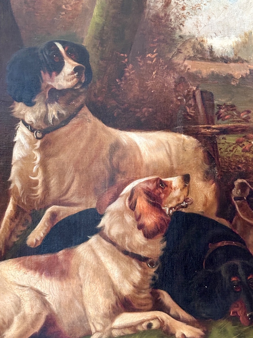 An oil painting on canvas depicting gun dogs lying beside harvested game birds in a rural landscape, framed in an ornate gold leaf frame. View II