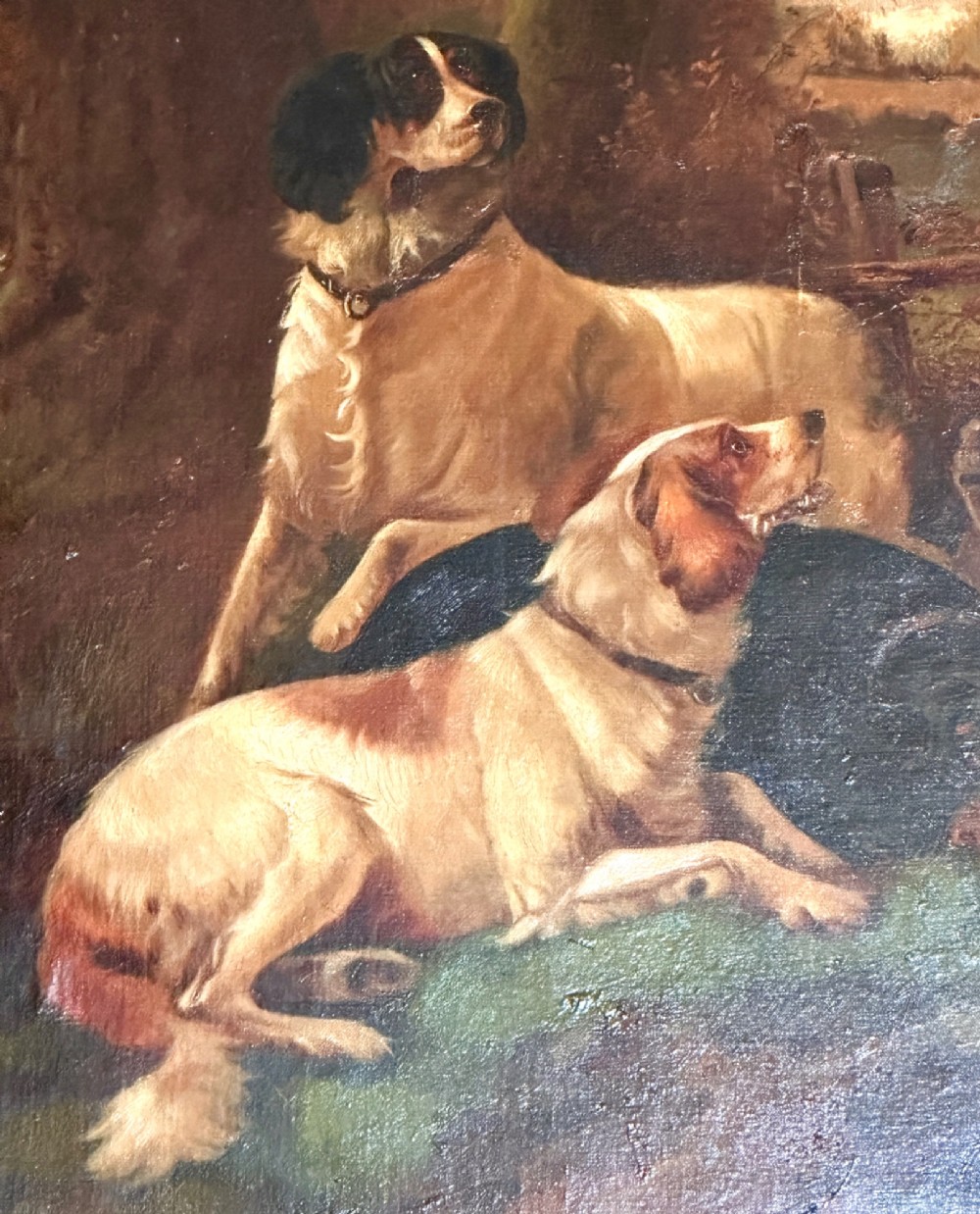 An oil painting on canvas depicting gun dogs lying beside harvested game birds in a rural landscape, framed in an ornate gold leaf frame. View X