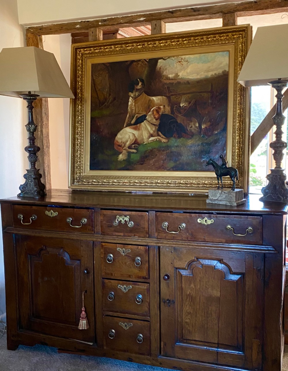 An oil painting on canvas depicting gun dogs lying beside harvested game birds in a rural landscape, framed in an ornate gold leaf frame. View XI