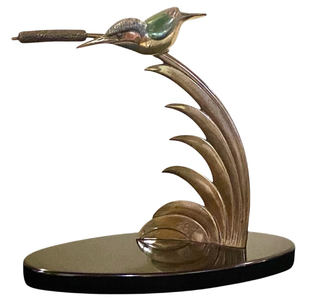An Art Deco cold-painted bronze sculpture depicting a stylized kingfisher perched on swept curved reeds, set upon an oval dark marble base.