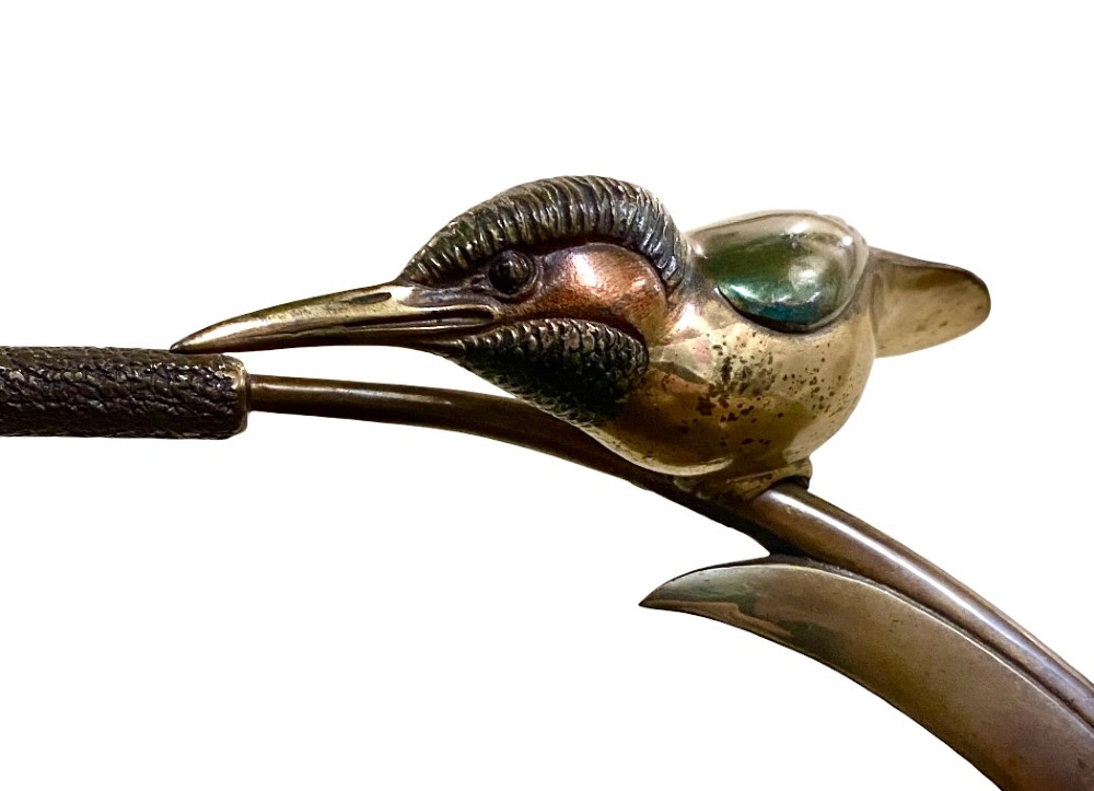 An Art Deco cold-painted bronze sculpture depicting a stylized kingfisher perched on swept curved reeds, set upon an oval dark marble base. View II