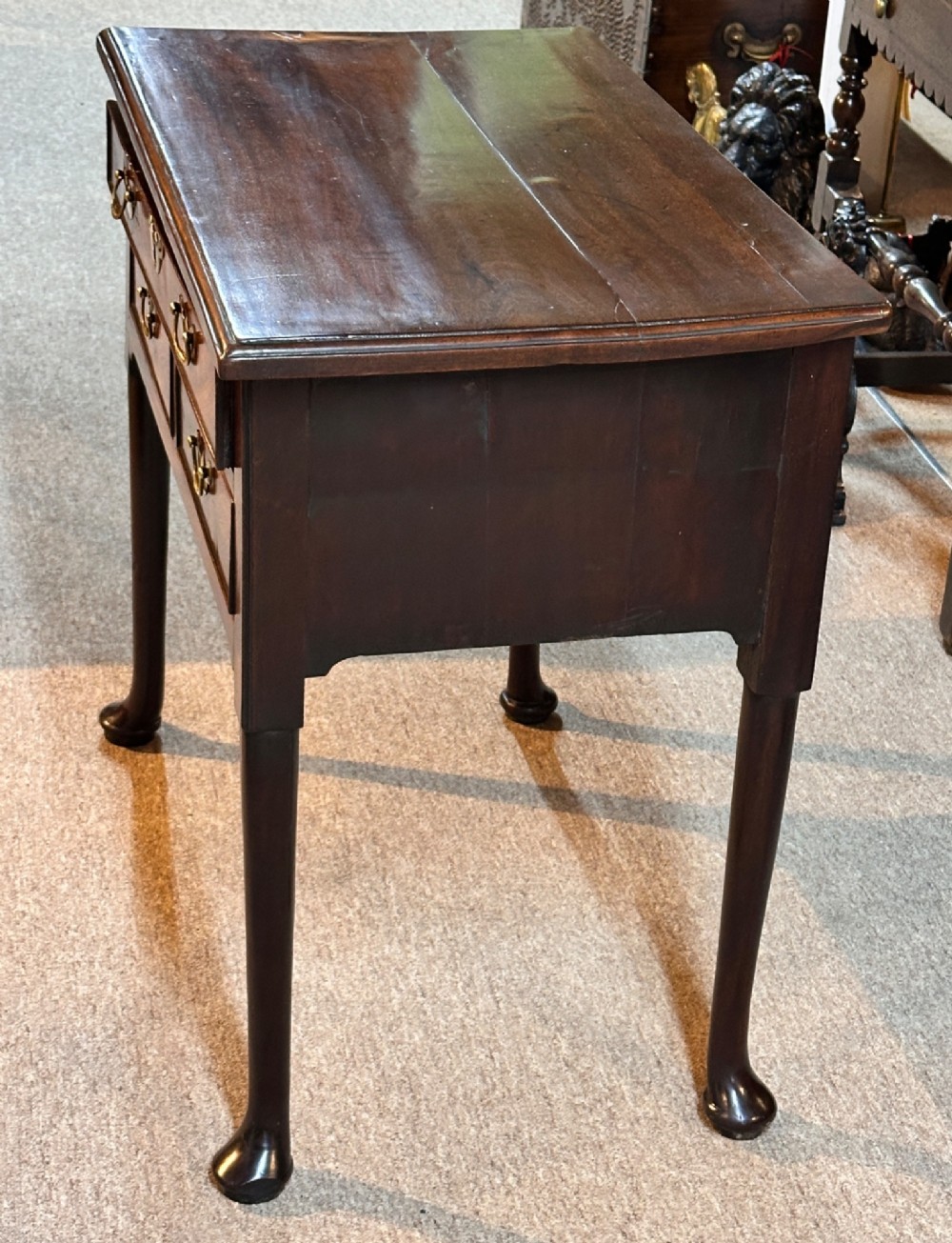 A George III mahogany lowboy featuring three brass-handled drawers, shaped aprons, and slender legs ending in pad feet. View V
