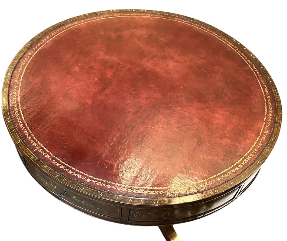 A circular antique mahogany drum table featuring a brown leather inset top, painted floral frieze drawers, and a central pedestal base on splayed legs with brass castors. View VIII