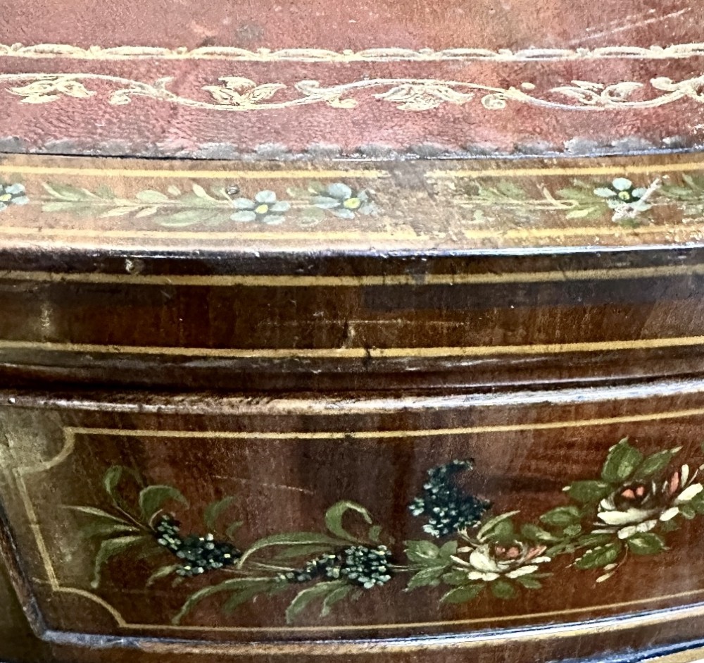 A circular antique mahogany drum table featuring a brown leather inset top, painted floral frieze drawers, and a central pedestal base on splayed legs with brass castors. View X