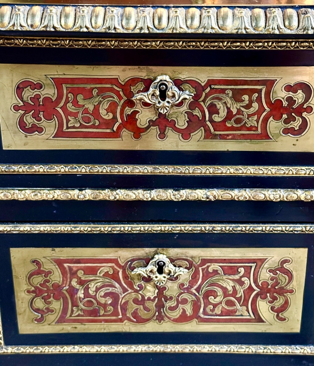 An ebonised French pedestal desk featuring red tortoiseshell and brass Boulle marquetry inlay, multiple drawers, a leather writing top, and a brass gallery. View XII