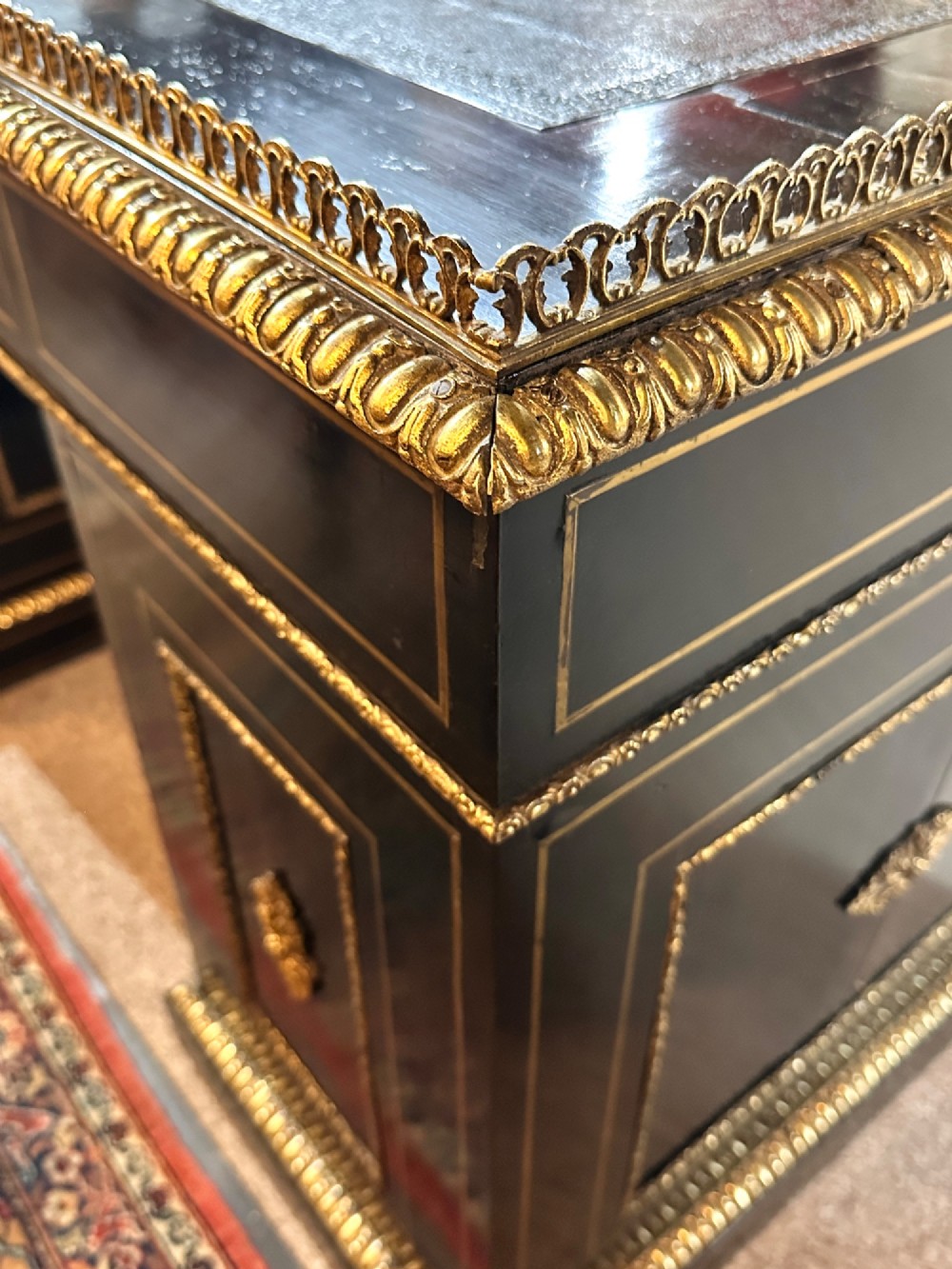 An ebonised French pedestal desk featuring red tortoiseshell and brass Boulle marquetry inlay, multiple drawers, a leather writing top, and a brass gallery. View XIII