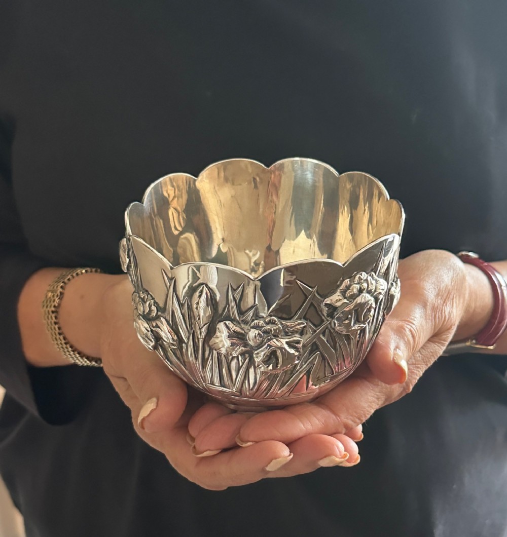 An antique Japanese silver bowl featuring high-relief repousse iris motifs and a scalloped lobed rim. View V