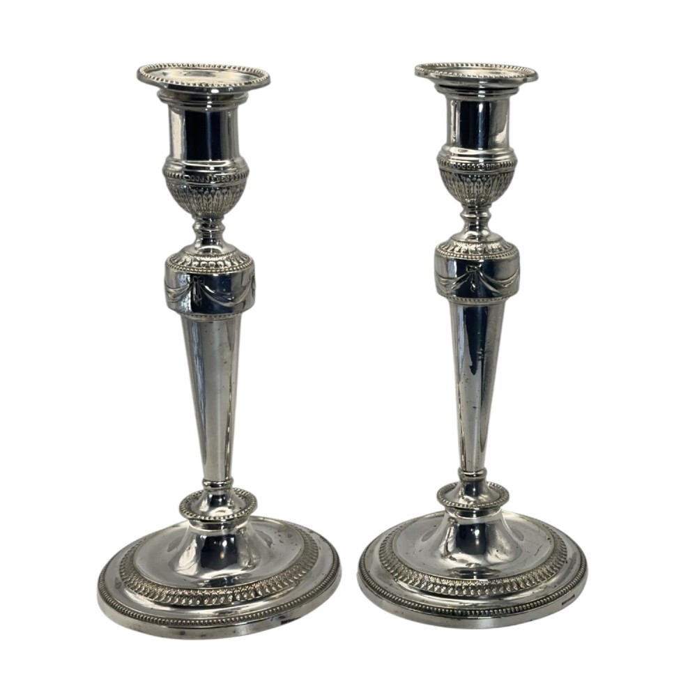 A pair of silver-plated candlesticks with tapered shafts, classical drapery swag motifs, and beaded circular bases. View II