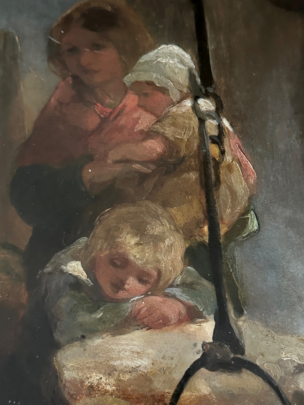 A framed Victorian oil painting depicting a rustic cottage interior with children gathered around an open hearth fire. View VI