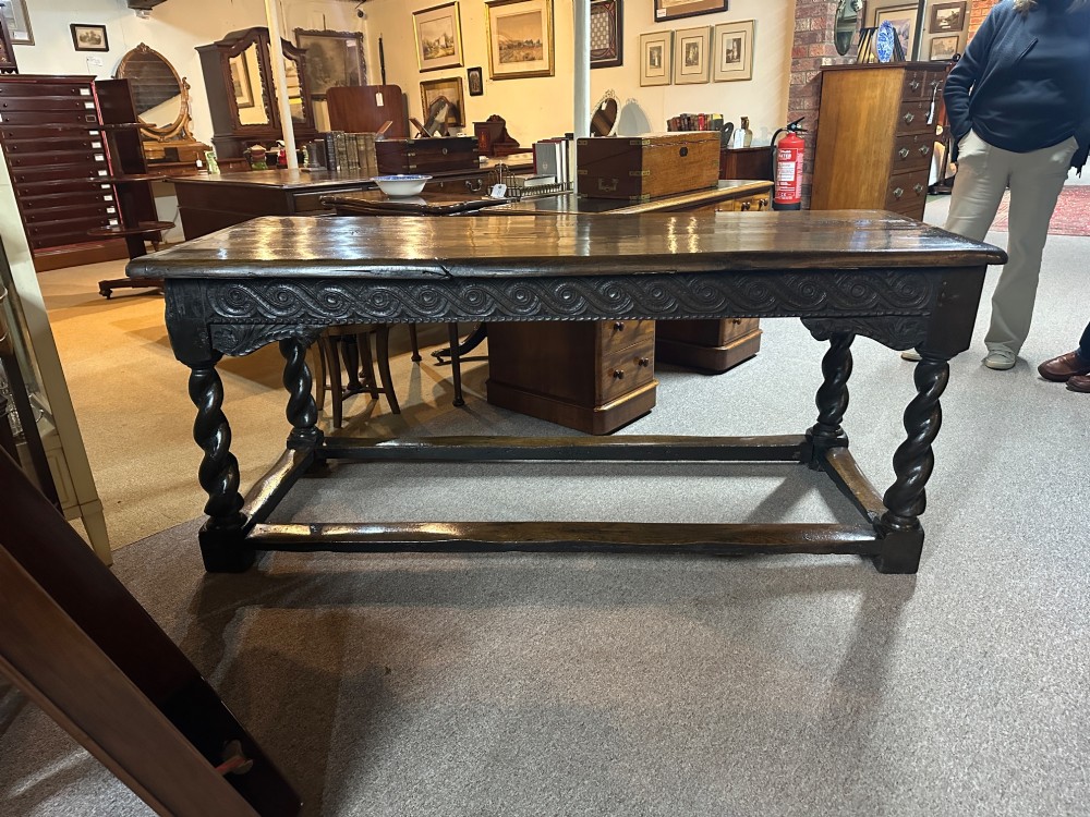 An 18th-century dark oak refectory table featuring carved apron details, spiral barley twist legs, and a perimeter stretcher base. View II
