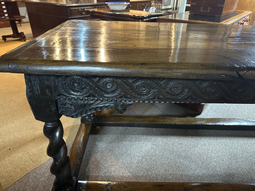 An 18th-century dark oak refectory table featuring carved apron details, spiral barley twist legs, and a perimeter stretcher base. View III
